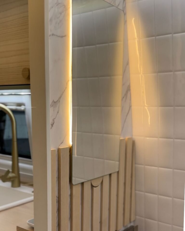 Banheiro da Sprinter 416 Extra Longa, com revestimento em mármore sintético e detalhes de iluminação com design moderno