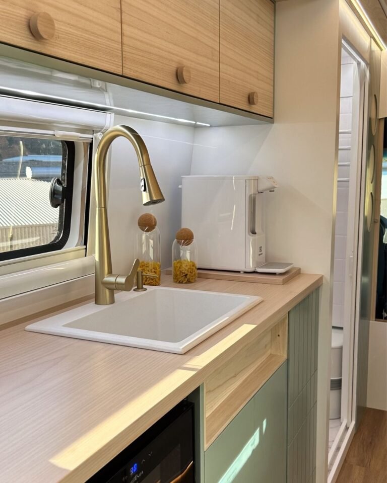 Cozinha compacta da Sprinter 416 Extra Longa, com fogão, pia, geladeira e armários em design moderno.