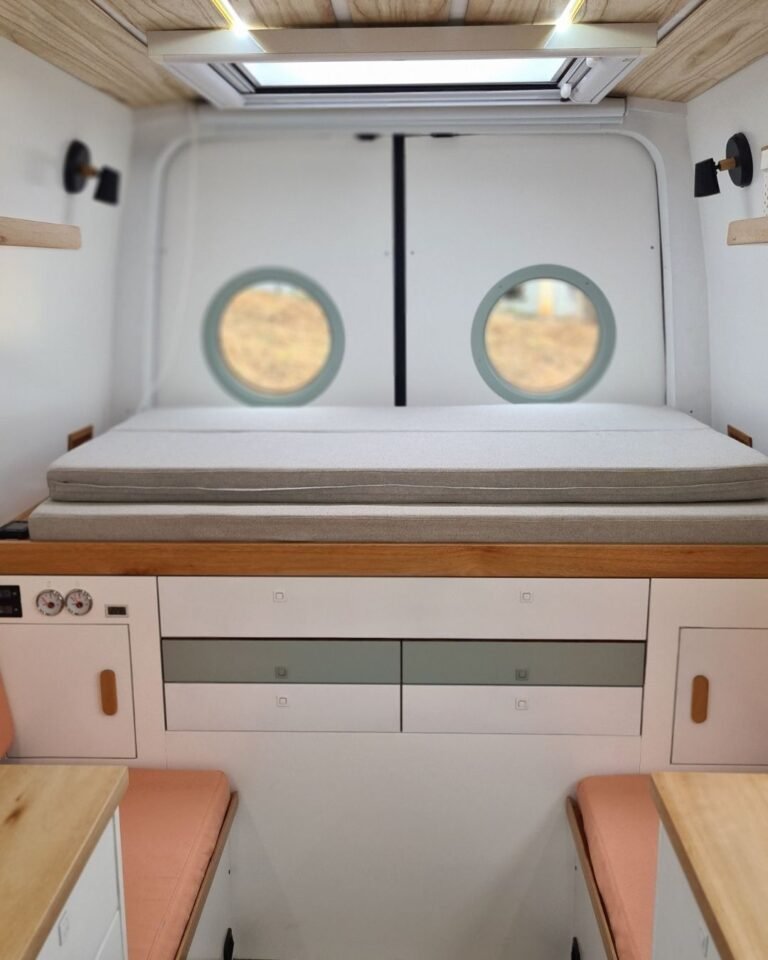 Quarto principal da Sprinter 416 Extra Longa, com cama queen size, mesas embutidas e iluminação suave, em tons