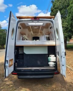 Porta-malas amplo abaixo da cama na Sprinter 416 Extra Longa, com espaço para armazenamento de malas, equipamentos e bicicleta elétrica