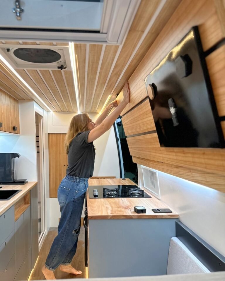 Cama extra retrátil da Sprinter Trio com acabamentos em madeira clara, em design moderno e funcional, ideal para viagens em grupo