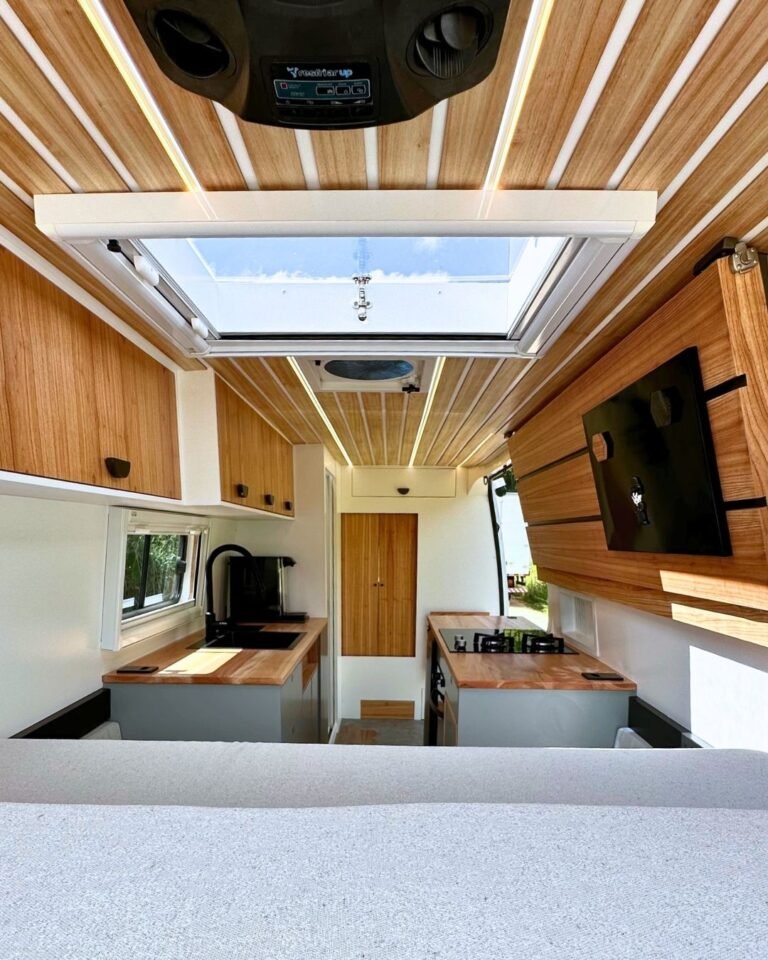 Quarto do motorhome Sprinter 417 com cama queen size e cama extra retrátil, em design moderno e funcional, ideal para viagens em família.