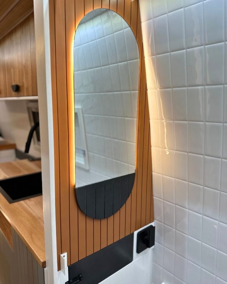 Banheiro do motorhome Sprinter Trio com pia retrátil e nichos inteligentes, em design moderno e funcional, ideal para viagens em família.