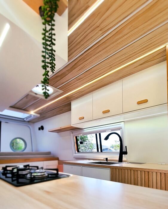 Detalhes de iluminação LED e decoração moderna no interior da Sprinter 416 Extra Longa, em tons claros e design contemporâneo