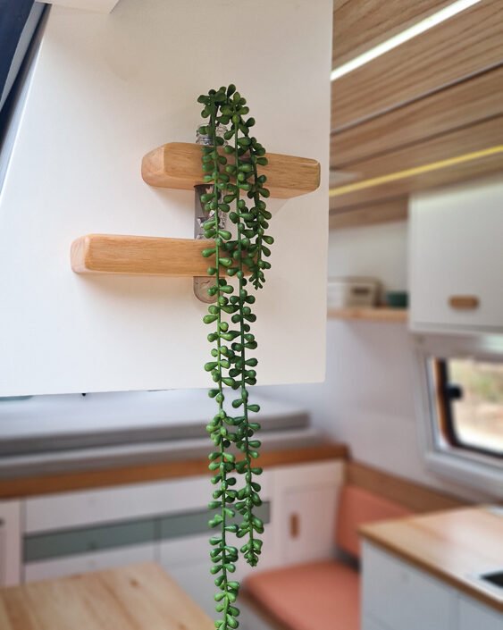 Detalhes de acabamento em madeira natural no interior da Sprinter 416 Extra Longa, com tons claros e design moderno